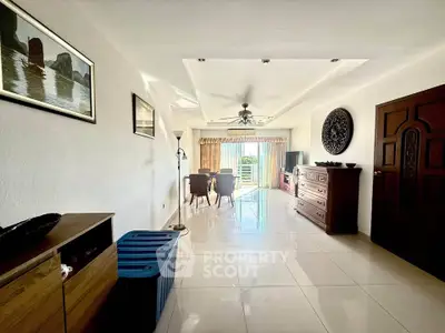 Spacious living room with elegant decor and natural light, featuring a dining area and balcony access.