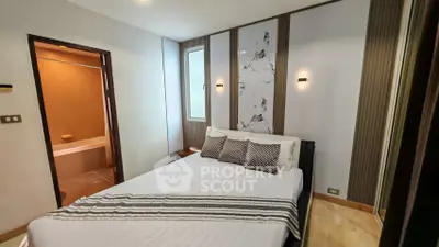 Modern bedroom with stylish decor and ensuite bathroom in a contemporary apartment.
