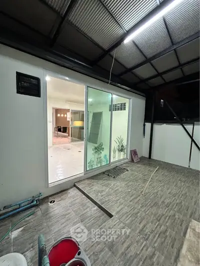 Modern patio with sliding glass doors leading to a stylish interior space.