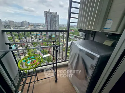 High-rise balcony with city view, featuring laundry area and drying rack.