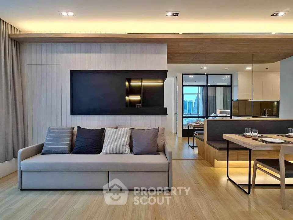 Modern open-layout living room with sleek kitchen and city view, featuring stylish furniture and ambient lighting.