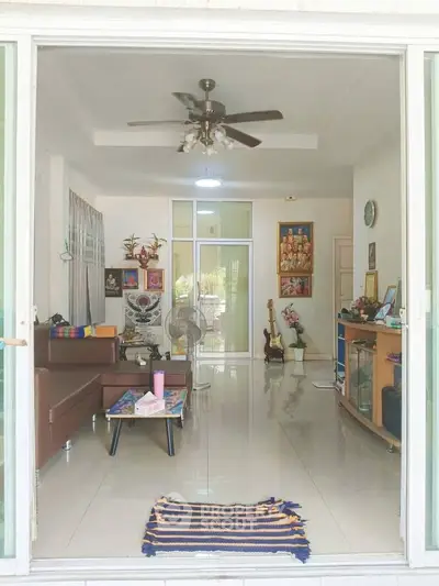 Spacious living room with modern decor and ceiling fan, perfect for relaxation and entertainment.