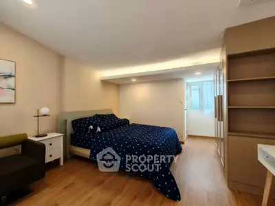 Spacious bedroom with modern decor and ample natural light, featuring a cozy bed and stylish furnishings.