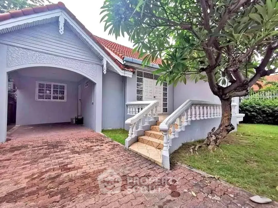 Charming single-story home with red-tiled roof and lush garden, perfect for family living.
