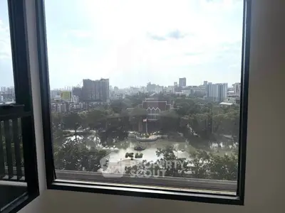 Stunning cityscape view from a high-rise window overlooking a serene park and urban skyline.