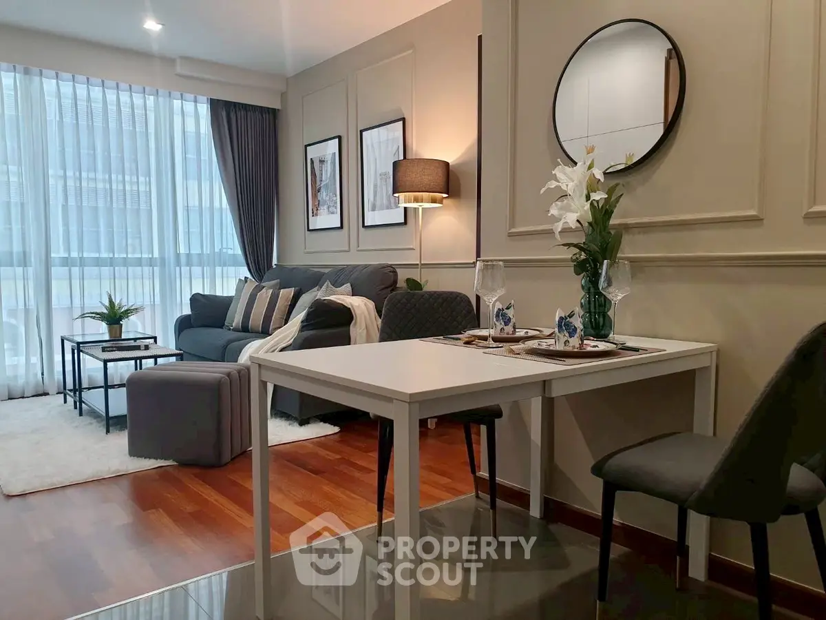 Modern living room with elegant decor and dining area, featuring stylish furniture and natural light.