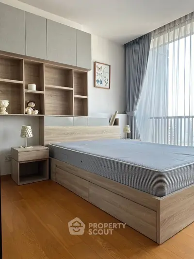 Modern bedroom with stylish wooden furniture and large window offering natural light