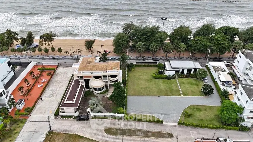 Stunning beachfront property with expansive lawn and ocean view, ideal for luxury living.