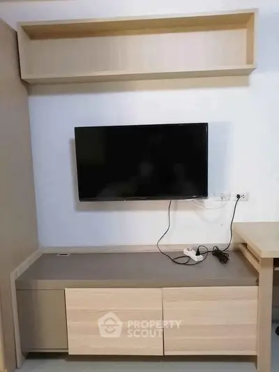 Modern living room with wall-mounted TV and sleek wooden cabinetry