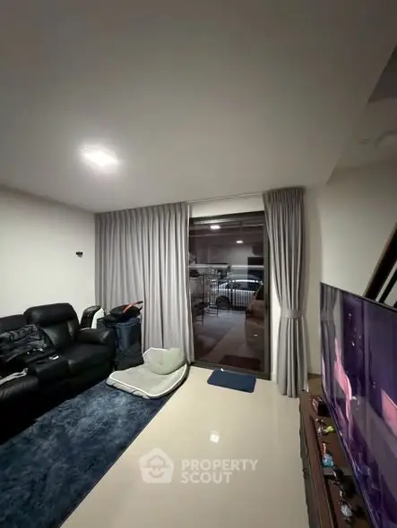 Modern living room with sleek furniture and large window view.