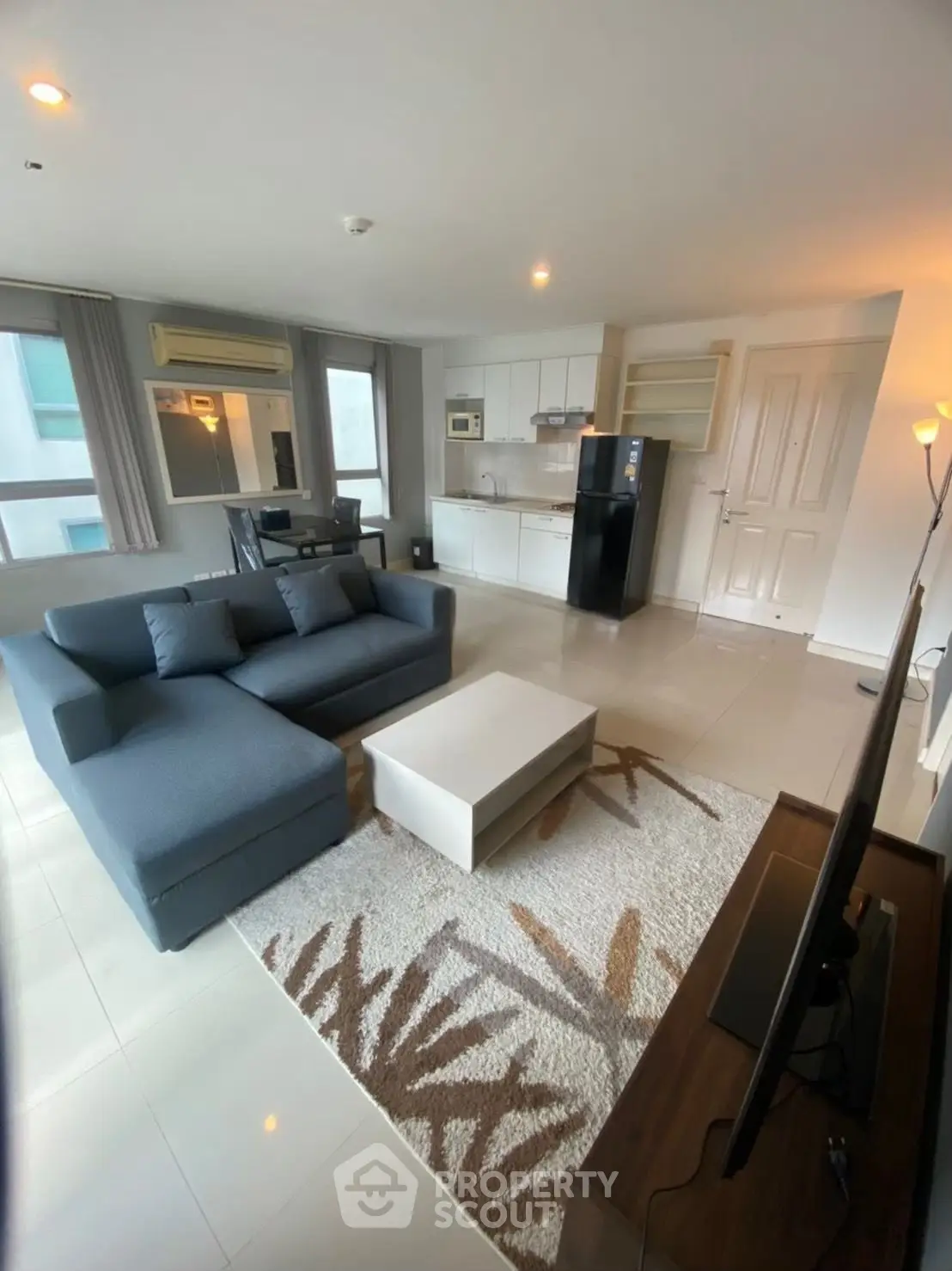 Spacious modern living room with open kitchen and stylish decor in a contemporary apartment.