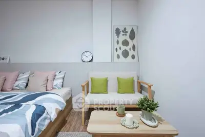Modern bedroom with stylish decor and cozy seating area, perfect for relaxation.