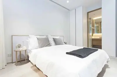 Modern minimalist bedroom with cozy white bedding and sleek decor