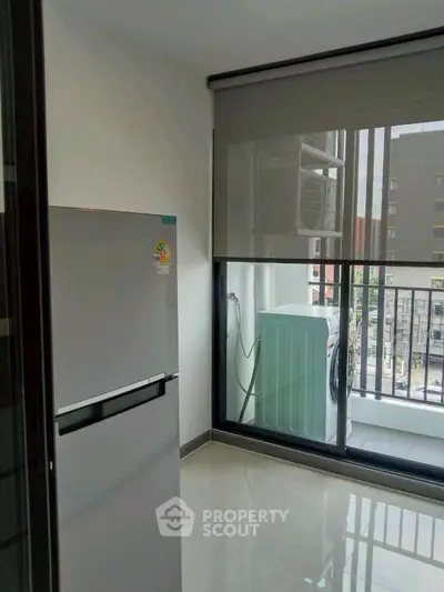Modern kitchen with sleek fridge and balcony view in urban apartment