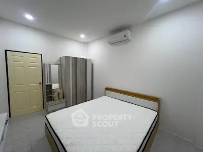 Modern bedroom with minimalist design featuring a comfortable bed and sleek wardrobe.