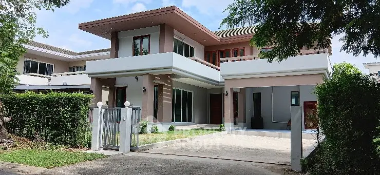 Modern two-story house with spacious driveway and lush greenery, perfect for family living.