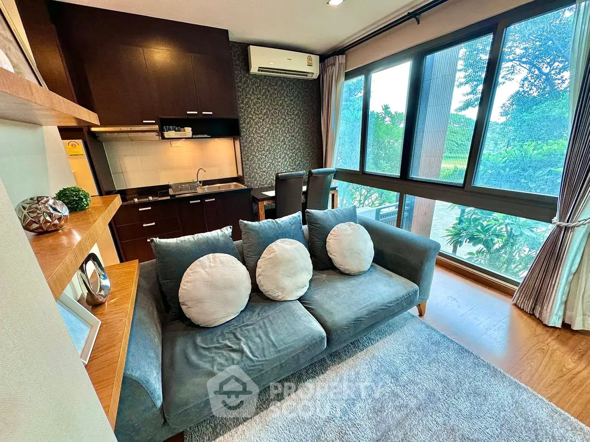 Chic living room with modern decor, large windows, and cozy seating in a stylish apartment.