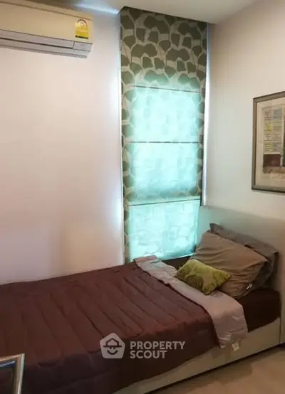 Cozy bedroom with single bed and air conditioning, perfect for a comfortable stay.