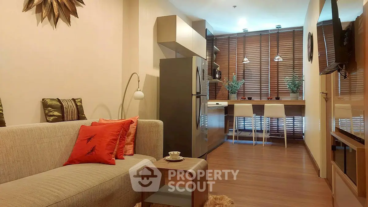 Modern living room with open kitchen, stylish decor, and cozy seating area.