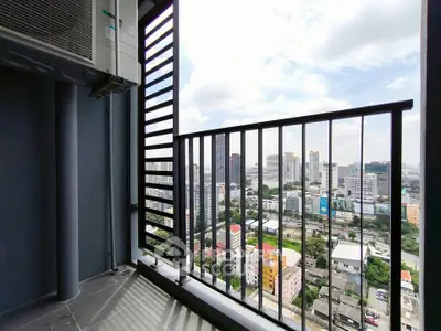 Stunning city view from high-rise balcony with modern railing and air conditioning unit.