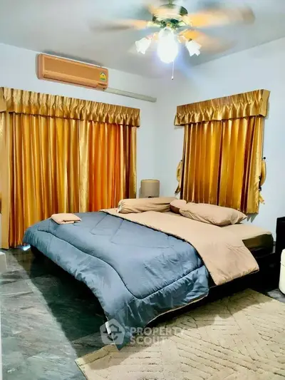 Cozy bedroom with elegant curtains and modern ceiling fan, perfect for relaxation.