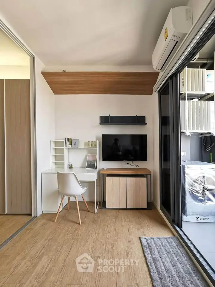 Modern study area with sleek desk, TV, and air conditioning in a stylish apartment.