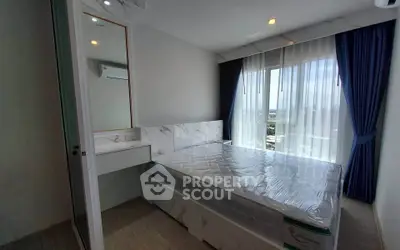 Modern bedroom with large windows and city view, featuring a neatly made bed and stylish curtains.