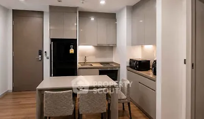 Modern kitchen with sleek cabinetry and dining area in contemporary apartment