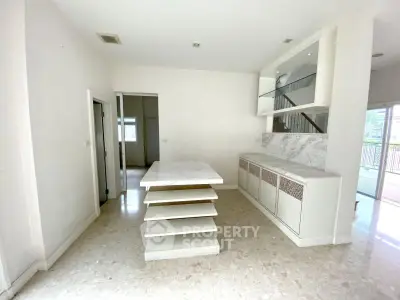 Spacious interior with marble island and built-in shelving, perfect for modern living.