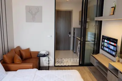 Modern studio apartment with stylish decor and smart TV, featuring a cozy living area and compact kitchen.