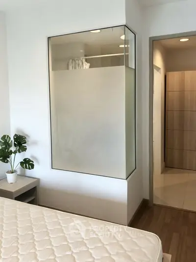 Modern bedroom with glass partition and wooden flooring