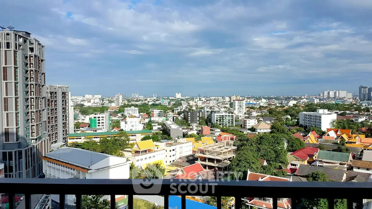 Stunning cityscape view from a high-rise balcony overlooking urban skyline and lush greenery.