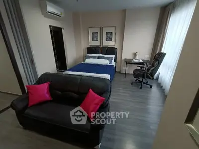 Modern bedroom with stylish decor and workspace, featuring a cozy bed and sleek furniture.