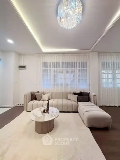 Luxurious living room with elegant chandelier and modern sectional sofa