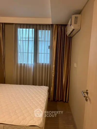 Cozy bedroom with air conditioning and elegant curtains, perfect for restful nights.