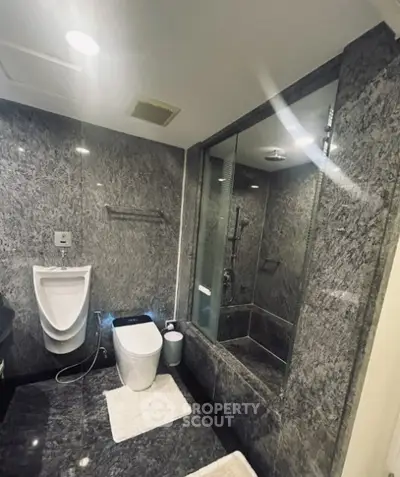Luxurious marble bathroom with modern fixtures and glass shower enclosure