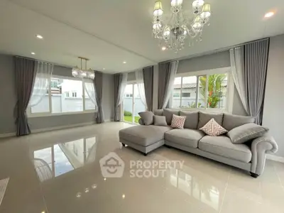 Spacious living room with elegant chandelier and large windows in modern home