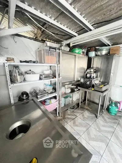 Compact kitchen with stainless steel counters and organized shelving