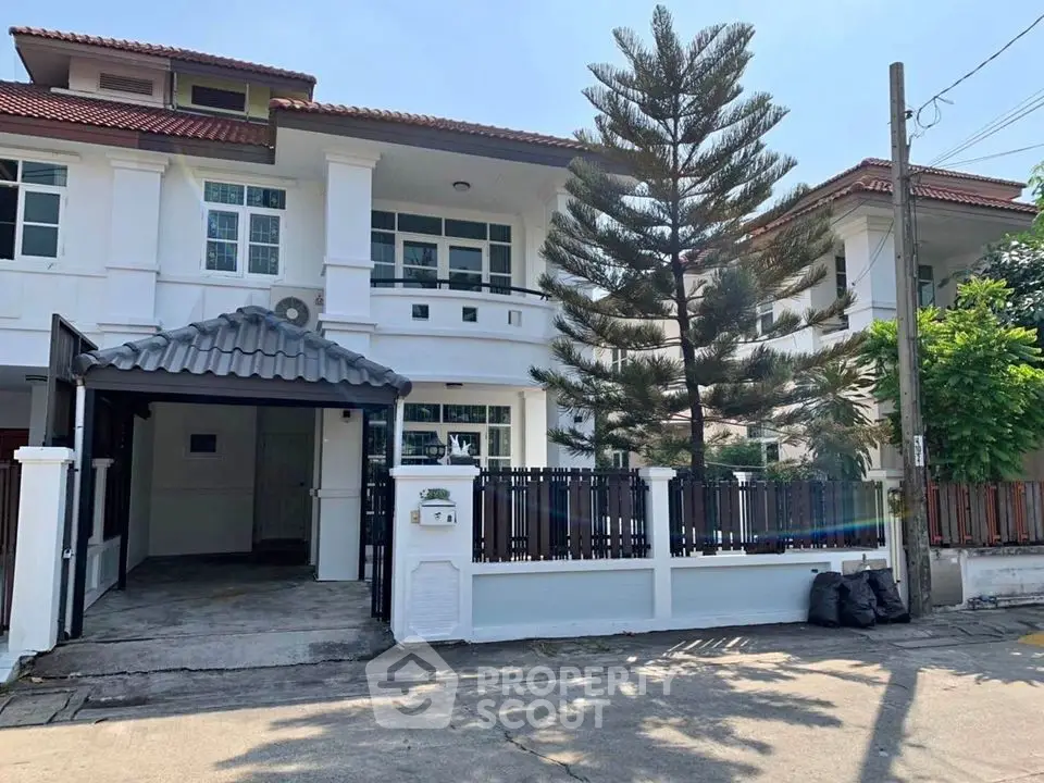Charming two-story house with spacious driveway and lush greenery in a serene neighborhood.