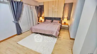 Spacious bedroom with elegant decor and cozy lighting, featuring a large bed and stylish curtains.
