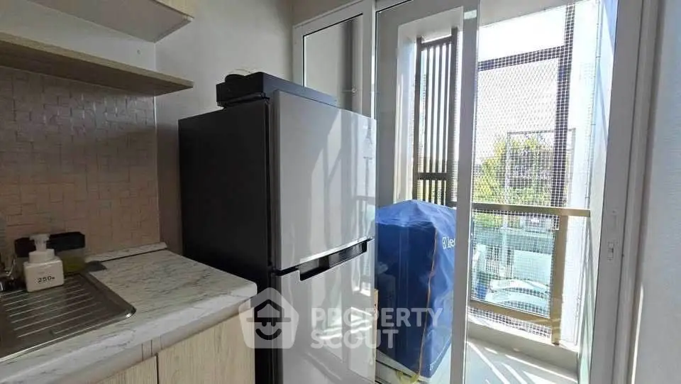 Modern kitchen with balcony view and sleek appliances