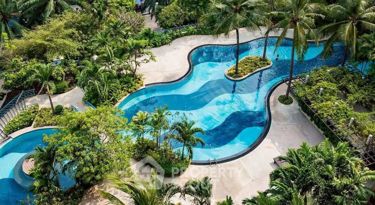 Luxurious tropical pool surrounded by lush greenery in a high-end residential complex.