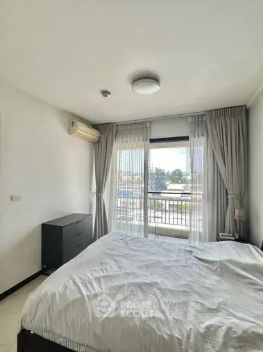 Bright and airy bedroom with large window offering ample natural light, complete with cozy bedding and modern furnishings for a comfortable living experience.