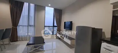 Modern living room with city view, sleek furniture, and large windows in a high-rise apartment.