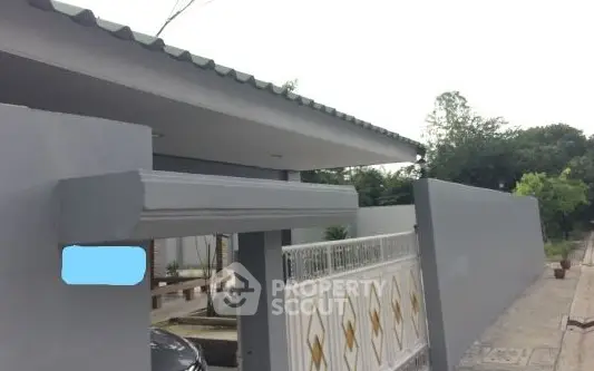 Modern house entrance with sleek gate and driveway