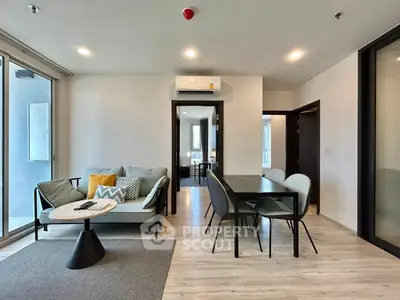 Modern living room with stylish furniture and dining area in open layout apartment.