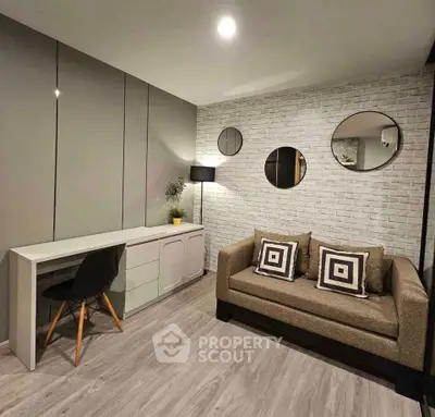 Modern living room with stylish decor, featuring a cozy sofa, sleek desk, and elegant wall mirrors.