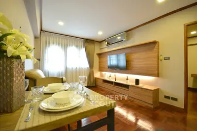 Modern living room with elegant decor and dining setup, featuring a wall-mounted TV and stylish lighting.