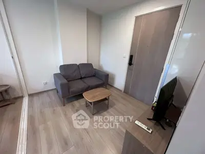 Cozy living room with modern sofa and TV, perfect for relaxation.