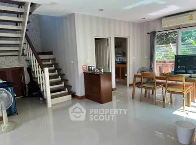 Spacious living room with dining area and staircase in modern home